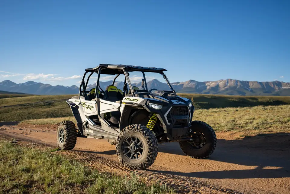 A RZR parked on a ridge road at golden hour