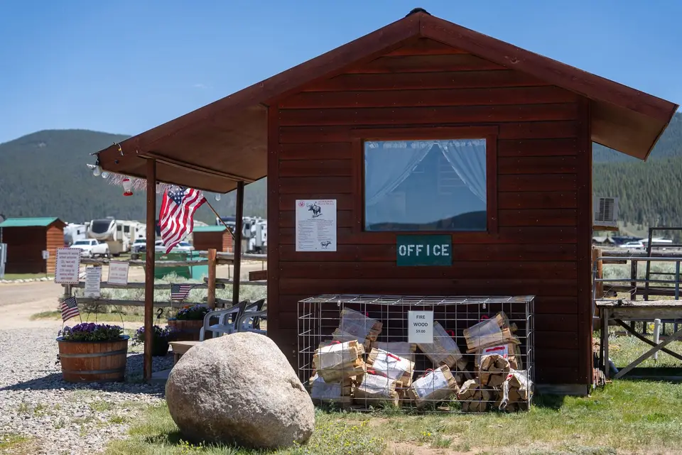 The RV office: a small log building with firewood stacked out front