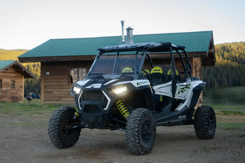 A rental RZR parked beside a log cabin