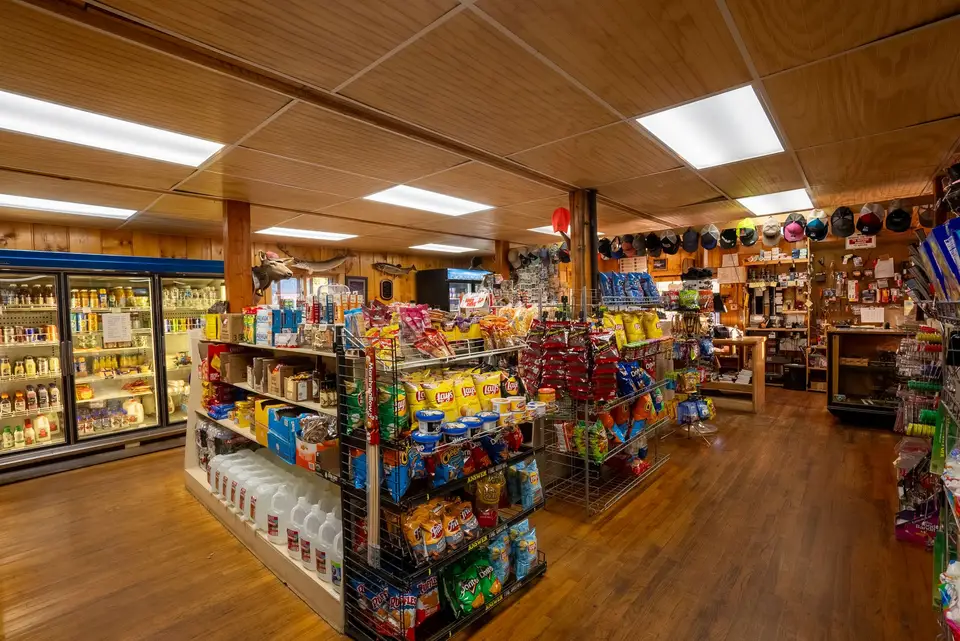 Inside the Trading Post: aisles of groceries, snacks and supplies under the log ceiling